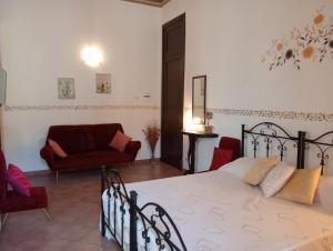 a bedroom with a bed and two chairs and a couch at Lunamuta b&b in Cetraro