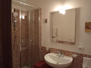 a bathroom with a sink and a shower with a mirror at Lunamuta b&b in Cetraro