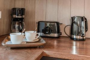 a counter with two coffee cups and a toaster at Tills Hüs in Utersum