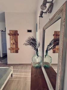 two vases sitting on a table in front of a mirror at Fotinis Apartment in Kalymnos