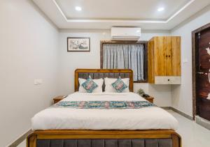 a bedroom with a bed with a wooden headboard at Hotel Prestige Grand, Manikonda in Haidar Sāhibgūda