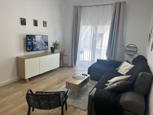 a living room with a blue couch and a tv at Piso Loli in Águilas