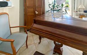a wooden piano and a chair in a room at Belle Maison Avec Piscine in Arcachon