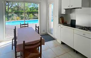 a kitchen with a table and a view of a pool at Belle Maison Avec Piscine in Arcachon