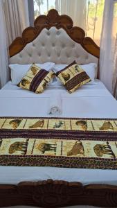 a bed with a wooden headboard and pillows on it at Westwood Homes in Kilifi