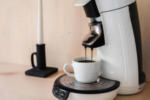 a coffee maker is making a cup of coffee at Hotel Bergamo Modern & zentral in Ludwigsburg 24h Check in 3 Min zum Schloss nachhaltiges Hotel in Holzbauweise in Ludwigsburg