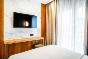 a hotel room with a bed and a flat screen tv at Boutique Hotel Villa Royal in Tivat