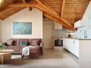 a living room with a couch and a kitchen at Athina Studios in Laganas +32 photos