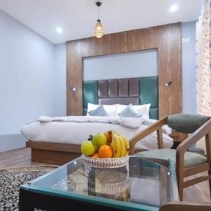 a bedroom with a bed and a table with fruit on it at Hotel Your Hive in Srinagar
