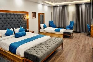 a hotel room with two beds and blue chairs at Kaldan Palace in Hundar
