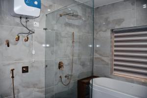a bathroom with a shower with a tub and a toilet at Kaldan Palace in Hundar