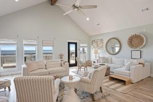 a living room with white furniture and a ceiling fan at Gulf State home in Crystal Beach