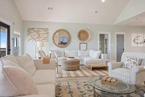 a living room with white furniture and a mirror at Gulf State home in Crystal Beach
