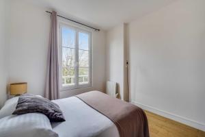 a bedroom with a bed and a window at Charming Apartment 2BR 4P - Saint-Cloud in Saint-Cloud +4 photos