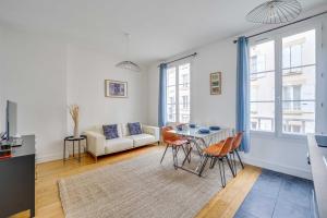 a living room with a table and chairs and a couch at Charming Apartment 2BR 4P - Saint-Cloud in Saint-Cloud
