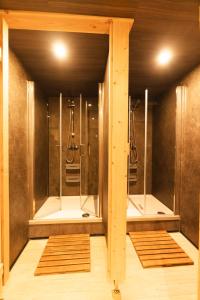 a bathroom with two walk in showers and mirrors at Bullhead House in Warmensteinach +77 photos