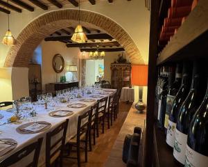 a long table in a room with wine bottles at Agriturismo Podere La Paolina - Residenza di Charme in Montefollonico +54 photos