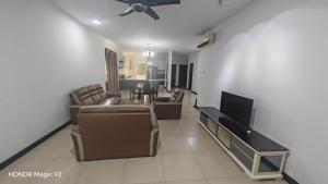 a living room with a couch and a flat screen tv at Pearl Regency Super Condominium in Gelugor