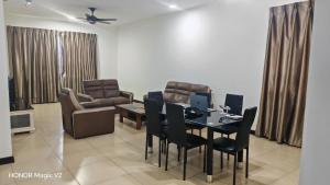 a dining room with a table and chairs and a couch at Pearl Regency Super Condominium in Gelugor