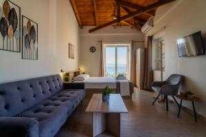 ein Wohnzimmer mit Sofa und Bett in der Unterkunft Lithino Rooms Kalamata in Kalamata