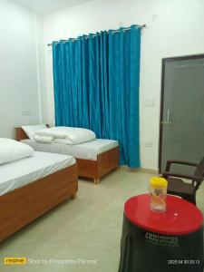 a room with two beds and a table with a glass on it at Hukkam Homestay in Barkot