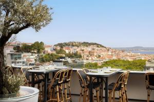 a balcony with tables and chairs and a view of the city at Tivoli Avenida Liberdade Lisboa – A Leading Hotel of the World in Lisbon