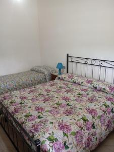 ein Schlafzimmer mit einem Bett mit einer geblümten Tagesdecke in der Unterkunft Carso in Alberese