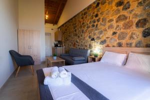 ein Schlafzimmer mit einem großen Bett und einer Steinwand in der Unterkunft Lithino Rooms Kalamata in Kalamata