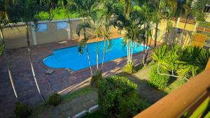 an overhead view of a swimming pool with palm trees at The Aviators Villa in Flic-en-Flac