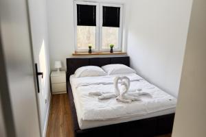 a bedroom with a bed with two towels on it at Park & Town Apartment in Drawsko Pomorskie