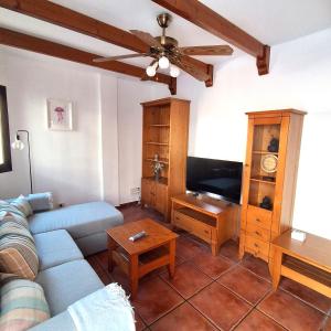 a living room with a couch and a tv at Sun Home Arinaga in Arinaga