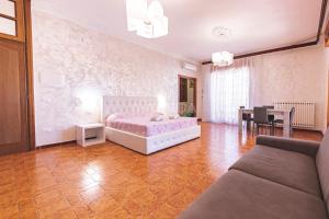a bedroom with a bed and a table and a couch at Porto Cesareo - Appartamenti e camere in Porto Cesareo
