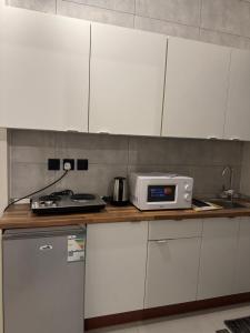 eine Küchenarbeitsplatte mit einem Toaster und einer Mikrowelle darauf in der Unterkunft شقق نسائم ورد in Ta'if