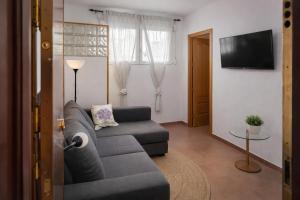 a living room with a couch and a television at Winahost Coslada Av Lisboa in Coslada