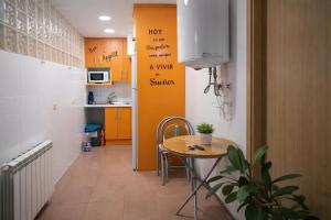 a room with a table and a kitchen with yellow cabinets at Winahost Coslada Av Lisboa in Coslada