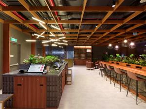 a restaurant with a row of tables and potted plants at SUPER HOTEL HANOI - Grand Opening in 17 March 2026 in Hanoi
