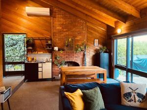 a living room with a couch and a brick fireplace at No 43 Guesthouse in Mount Beauty