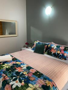 a bedroom with a bed with a floral comforter at No 43 Guesthouse in Mount Beauty