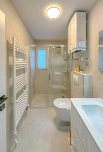 a bathroom with a shower and a toilet and a sink at Apartment Maraska in Zadar +46 photos