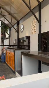 a large kitchen with a clock on the wall at Neems paradise in Point Pedro