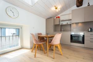 a kitchen with a table and chairs and a clock at Stay Bergamo Centro in Bergamo