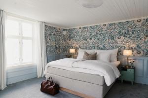 a bedroom with a large bed with floral wallpaper at Nusfjord Village & Resort in Nussfjord