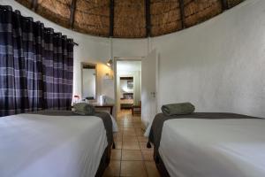 a bedroom with two beds and a room with a table at Van Zylsvlei - A Karoo Guest Farm in Colesberg