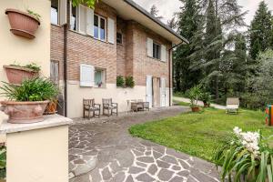 a courtyard of a house with chairs and plants at B&B Mama Rò in Cesena +23 photos