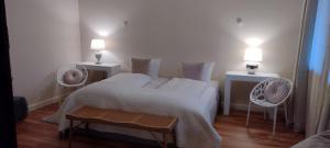 a bedroom with a bed with two chairs and two lights at DAS KLEINE HOTEL IPHOFEN, klimatisierte Zimmer- 55" TV, TV mirroring, kleines Secret mit Garten & Terrassen, nahe aller VDP Weingüter, Hunde willkommen, fine dining, nahe KNAUF GIPS KG und KNAUF IT ConneKT in Iphofen