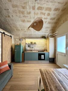 a living room with a couch and a kitchen at Dimora Antica Santa Chiara in Trani