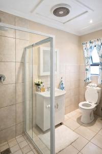 a bathroom with a toilet and a sink and a shower at Honey Cove in Mossel Bay