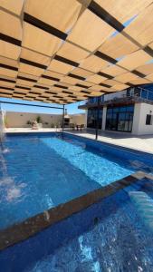 a large swimming pool with a large building with a roof at سبانا شاليه in Jerash