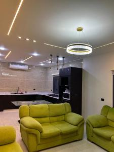 a living room with a couch and a kitchen at سبانا شاليه in Jerash