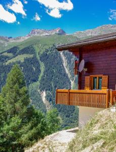 a house on a hill with a view of the mountains at Chalet Charis in Bellwald